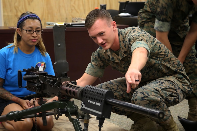Margarita Frye is instructed by Sgt. Trevor Bastion on the functions of the M2 Browning.50 caliber machine gun during “Marine for a Day,” an event hosted at Marine Corps Air Station New River, N.C., Sept. 23, 2016. The purpose of the event was to give spouses a better perspective of the mental and physical demands their Marines go through on a day-to-day basis in order to maintain their personal readiness. The event included hands-on practice at the Indoor Simulated Marksmanship Trainer, a tour of the various aircraft aboard the air station, Marine Corps Martial Arts Program familiarization, a combat fitness test and more. Bastion is an intelligence specialist with MAG-29, 2nd Marine Aircraft Wing. (U.S. Marine Corps photo by Lance Cpl. Mackenzie Gibson/Released)