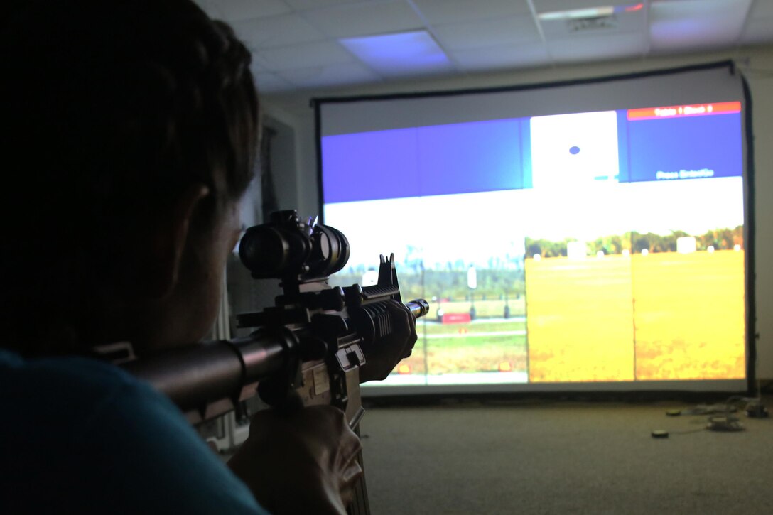 A spouse of a Marine with Marine Aircraft Group 29 fires the M-4 carbine in the Indoor Simulated Marksmanship Trainer during “Marine for a Day,” an event hosted at Marine Corps Air Station New River, N.C., Sept. 23, 2016. The purpose of the event was to give spouses a better perspective of the mental and physical demands their Marines go through on a day-to-day basis in order to maintain their personal readiness. The event included hands-on practice at the Indoor Simulated Marksmanship Trainer, a tour of the various aircraft aboard the air station, Marine Corps Martial Arts Program familiarization, a combat fitness test and more. (U.S. Marine Corps photo by Lance Cpl. Mackenzie Gibson/Released)
