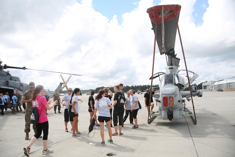 Spouses of Marines with Marine Aircraft Group 29 are shown various aircraft during “Marine for a Day,” an event hosted at Marine Corps Air Station New River, N.C., Sept. 23, 2016. The purpose of the event was to give spouses a better perspective of the mental and physical demands their Marines go through on a day-to-day basis in order to maintain their personal readiness. The event included hands-on practice at the Indoor Simulated Marksmanship Trainer, a tour of the various aircraft aboard the air station, Marine Corps Martial Arts Program familiarization, a combat fitness test and more. (U.S. Marine Corps photo by Lance Cpl. Mackenzie Gibson/Released)