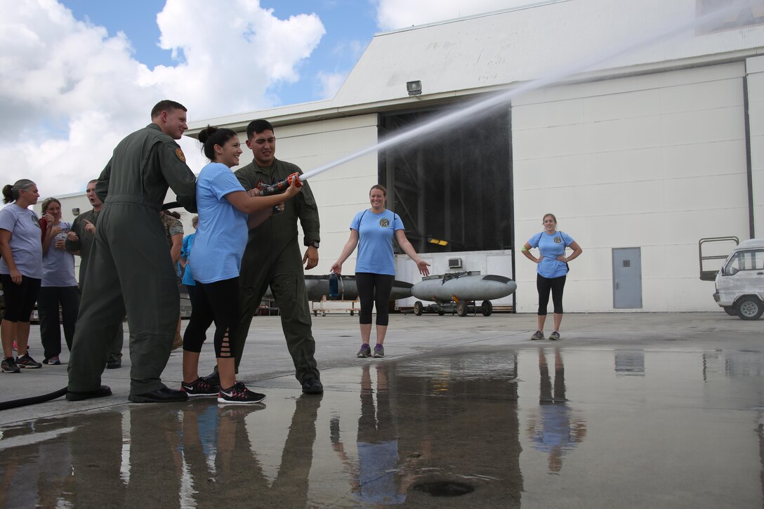 A spouse of a Marine with Marine Aircraft Group 29 sprays a fire hose from an aircraft rescue and firefighting truck during “Marine for a Day,” an event hosted at Marine Corps Air Station New River, N.C., Sept. 23, 2016. The purpose of the event was to give spouses a better perspective of the mental and physical demands their Marines go through on a day-to-day basis in order to maintain their personal readiness. The event included hands-on practice at the Indoor Simulated Marksmanship Trainer, a tour of the various aircraft aboard the air station, Marine Corps Martial Arts Program familiarization, a combat fitness test and more. (U.S. Marine Corps photo by Lance Cpl. Mackenzie Gibson/Released)