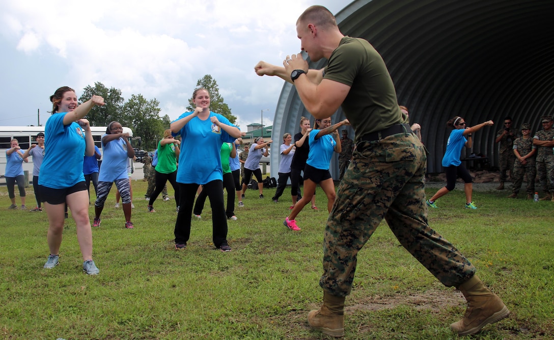 Sgt. Matthew Ainsworth teaches spouses of Marines with Marine Aircraft Group 29 the basics of the Marine Corps Martial Arts Program during “Marine for a Day,” an event hosted at Marine Corps Air Station New River, N.C., Sept. 23, 2016. The purpose of the event was to give spouses a better perspective of the mental and physical demands their Marines go through on a day-to-day basis in order to maintain their personal readiness. The event included hands-on practice at the Indoor Simulated Marksmanship Trainer, a tour of the various aircraft aboard the air station, Marine Corps Martial Arts Program familiarization, a combat fitness test and more. Ainsworth is a helicopter tilt rotter dynamics component mechanic with Marine Aircraft Logistics Squadron 29, Marine Aircraft Group 29, 2nd Marine Aircraft Wing. (U.S. Marine Corps photo by Lance Cpl. Mackenzie Gibson/Released)