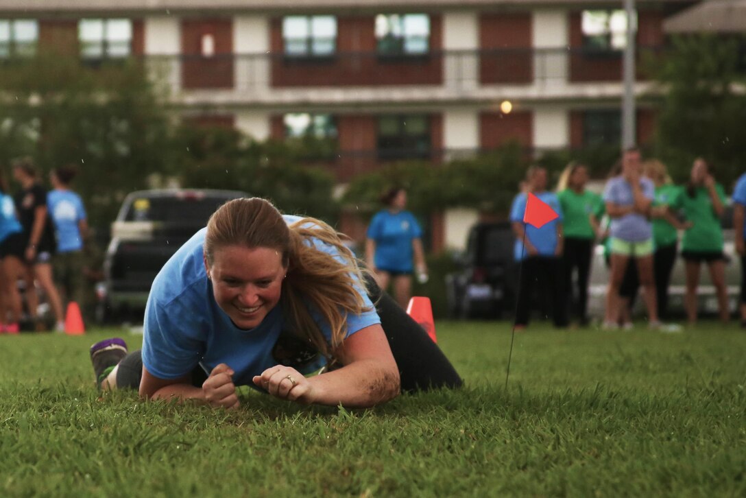 A spouse of a Marine with Marine Aircraft Group 29 low crawls for the Marine Corps combat fitness test during “Marine for a Day,” an event hosted at Marine Corps Air Station New River, N.C., Sept. 23, 2016. The purpose of the event was to give spouses a better perspective of the mental and physical demands their Marines go through on a day-to-day basis in order to maintain their personal readiness. The event included hands-on practice at the Indoor Simulated Marksmanship Trainer, a tour of the various aircraft aboard the air station, Marine Corps Martial Arts Program familiarization, a combat fitness test and more. (U.S. Marine Corps photo by Lance Cpl. Mackenzie Gibson/Released)