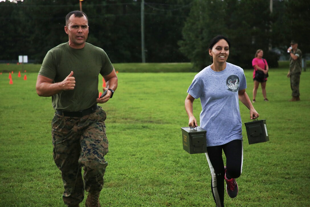 Gunnery Sgt. Justin Frye motivates a spouse of a Marine with Marine Aircraft Group 29 finishing a combat fitness test during “Marine for a Day,” an event hosted at Marine Corps Air Station New River, N.C., Sept. 23, 2016. The purpose of the event was to give spouses a better perspective of the mental and physical demands their Marines go through on a day-to-day basis in order to maintain their personal readiness. The event included hands-on practice at the Indoor Simulated Marksmanship Trainer, a tour of the various aircraft aboard the air station, Marine Corps Martial Arts Program familiarization, a combat fitness test and more. Frye is an embarkation chief with Marine Heavy Helicopter Squadron 461. (U.S. Marine Corps photo by Lance Cpl. Mackenzie Gibson/Released)