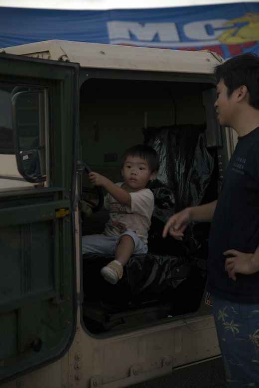 A child sits in the driver’s seat of a Humvee Sept. 24 during the annual Flight Line Fair at Marine Corps Air Station Futenma, Okinawa, Japan. MCAS Futenma opened its flight line to Status of Forces Agreement Personnel and Okinawa residents to enjoy local vendors, games and live musical performances. Marines stood by their vehicles to answer observers’ questions about the vehicles, their occupations, and their daily lives as service members. The fair is one of the many community events hosted by Marines on the station that strengthen the relationship between SOFA members and Okinawa residents.