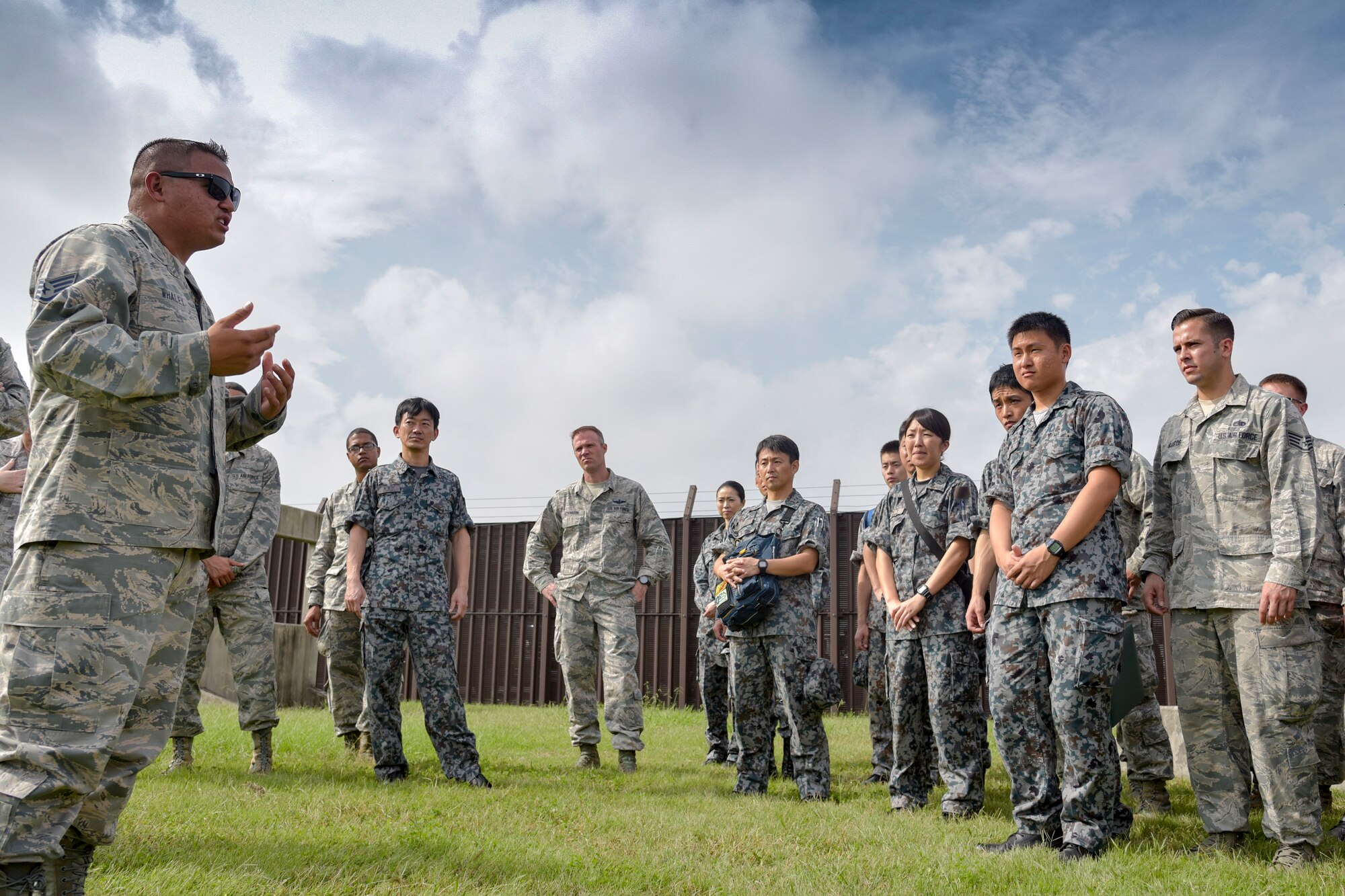 U.S. Air Force Staff Sgt. Robert Whaley, left, 374th Security Forces Squadron military working dog trainer, speaks with Japan Air Self-Defense Force members during the Bilateral Exchange Program at Yokota Air Base, Japan, Sept. 28, 2016. U.S. Air Force Airmen and JASDF members had opportunities to work together and learn from each other's daily operations during the 11-day program. (U.S. Air Force photo by Machiko Imai/Released)