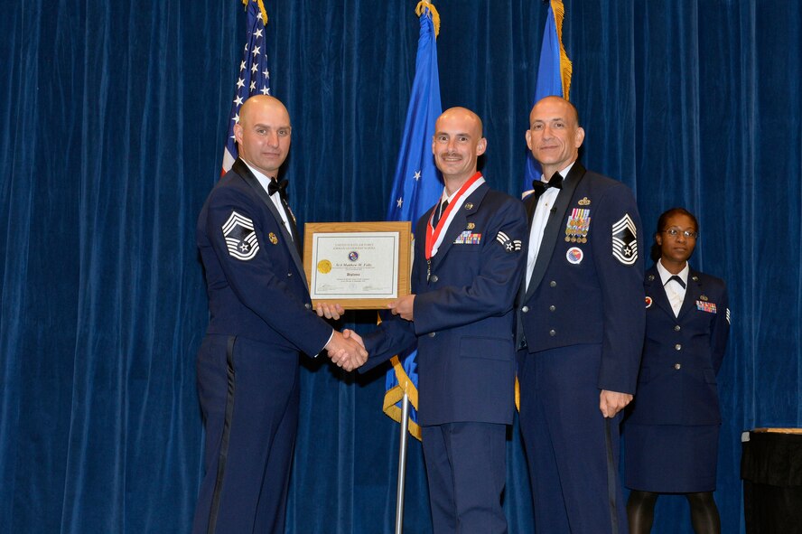 Senior Airman Matthew Foltz receives the Distinguished Graduate Award for Airman leadership school class 16-9 from Chief Master Sgt. Paul Rayman, Chief Master Sgt. of Reserve Forces for Headquarters Air Force Space Command, and Chief Master Sgt. Edward Walden, Sr., Commandant of the Paul H. Lankford Enlisted PME Center, here, Sep. 27, 2016, at the I. G. Brown Training and Education Center. The distinguished graduate award is presented to students in the top 10 percent of the class. (U.S. Air National Guard photo by Master Sgt. Jerry D. Harlan/Released)