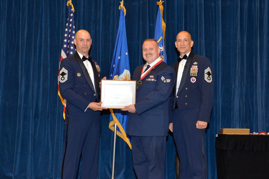 Senior Airman Ryan Coomer receives the Distinguished Graduate Award for Airman leadership school class 16-9 from Chief Master Sgt. Paul Rayman, Chief Master Sgt. of Reserve Forces for Headquarters Air Force Space Command, and Chief Master Sgt. Edward Walden, Sr., Commandant of the Paul H. Lankford Enlisted PME Center, here, Sep. 27, 2016, at the I. G. Brown Training and Education Center. The distinguished graduate award is presented to students in the top 10 percent of the class. (U.S. Air National Guard photo by Master Sgt. Jerry D. Harlan/Released)