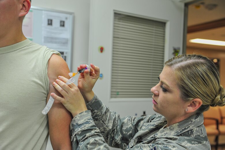 Tech. Sgt. Greer Keith NCO in charge of immunizations with the 18th Medical Group administers an influenza shot at the Kadena Clinic on Sept. 29, 2016, at Kadena Air Base, Japan. The flu is a contagious respiratory illness caused by influenza viruses that infect the nose, throat, and lungs. (U.S. Air Force photo by Airman 1st Class Nick Emerick) 