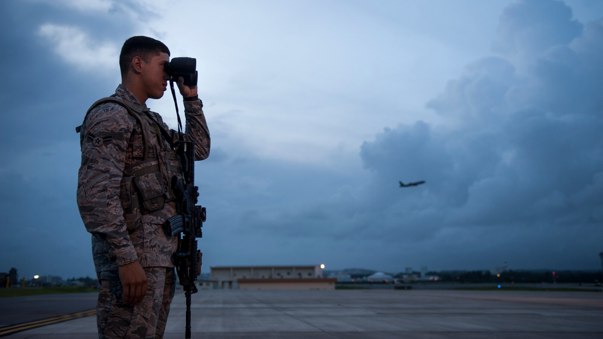 U.S. Air Force Airman 1st Class Jose Olivera, 18th Security Forces Squadron response force member, scans the flightline with binoculars Sept. 27, 2016, at Kadena Air Base, Japan. By maintaining constant watch over flightline assets, Olivera helps prevent unauthorized activity from hindering Kadena’s aircraft operations.  (U.S. Air Force photo by Senior Airman Peter Reft)