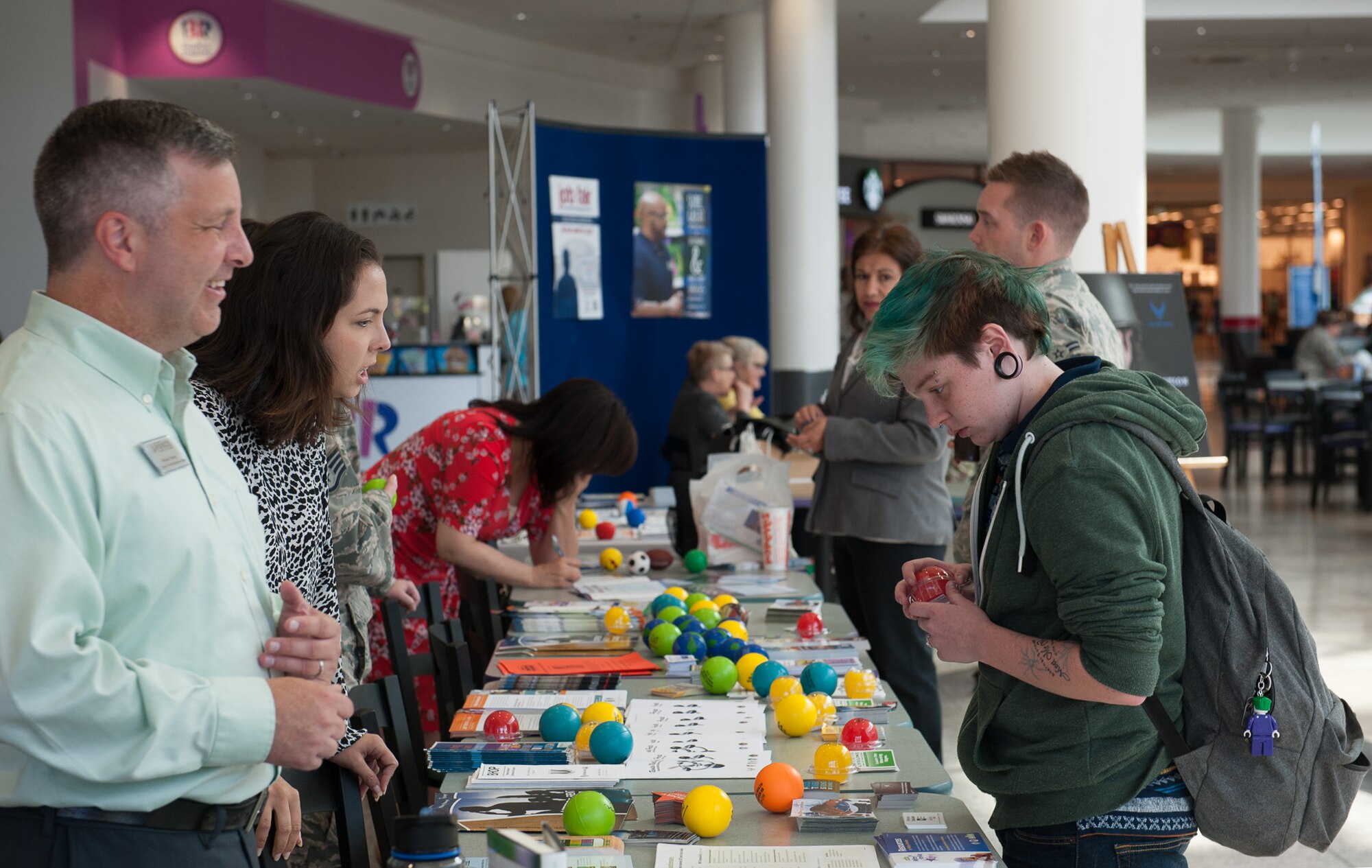 Wesley Yancey, the 86th Force Support Squadron Airman and Family Readiness Center’s Exceptional Family Member program manager, greets a visitor as they look over a table covered in stress balls at a sucide prevention fair Sept. 22, 2016, at Ramstein Air Base, Germany. Stress balls were offered to all visitors who came to the event.