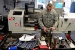 Army Sgt. Wesley Todd, with the Illinois Army National Guard’s 333rd Military Police Company, checks the measurements on a device he invented that makes removing a siezed howitzer muzzle break easier and safer for Soldiers when performing repairs or maintenance on the guns. The device has been adopted by the Army and is scheduled to be manufactured and distributed to maintenance organizations Army-wide. 