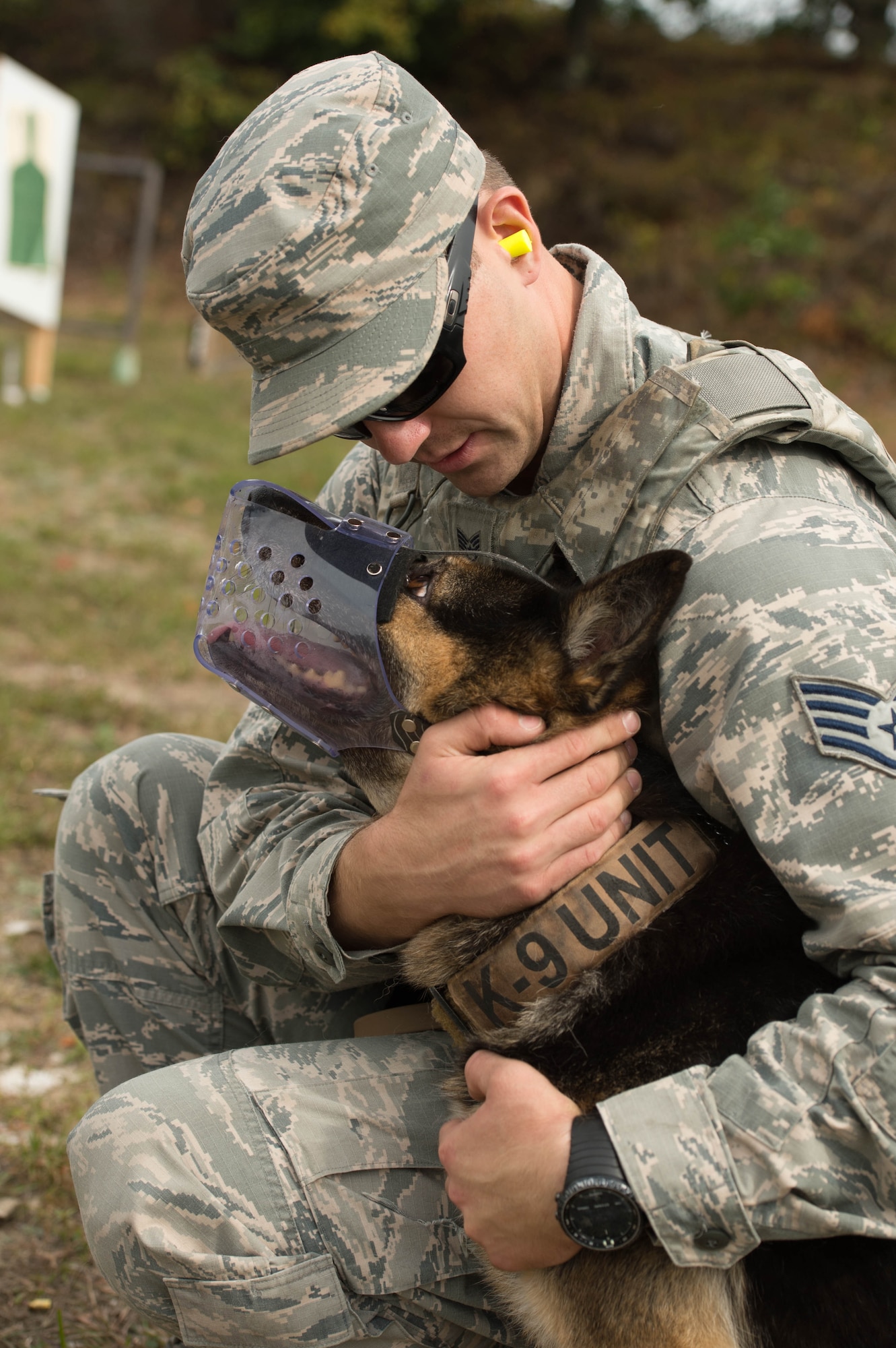 Staff Sgt. David Schultz, 66th Security Forces Squadron Military Working Dog handler, rewards MWD Peta for being obedient during a live fire training exercise at Fort Devens, Mass., Sept. 27. Airmen and their military working dogs participated in the training to improve their ability to work together as a team. (U.S. Air Force photo by Jerry Saslav)