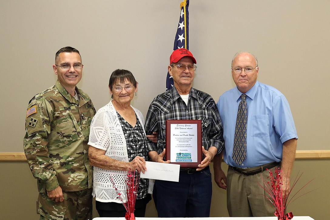 Col. Christopher Hussin, Commander, Tulsa District, U.S. Army Corps of Engineers joins Greg Miller, Chairperson Board of Directors, The Corps Foundation, in presenting Orville and Pauline Nichols with the “Volunteer Enduring Service Award,” Sept. 22, at the Case Community Center, Sand Springs, Okla.  The Nichols received the national award for their contribution of over 26,000 hours of volunteer work to Keystone Lake.