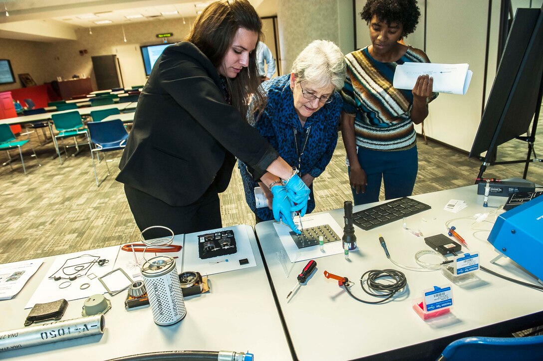 Meghan Kipp (left), Applied DNA Sciences’ technical product manager Government and Military Programs, demonstrates current DNA marking technology to DLA Land and Maritime associates during their research and development update visit.