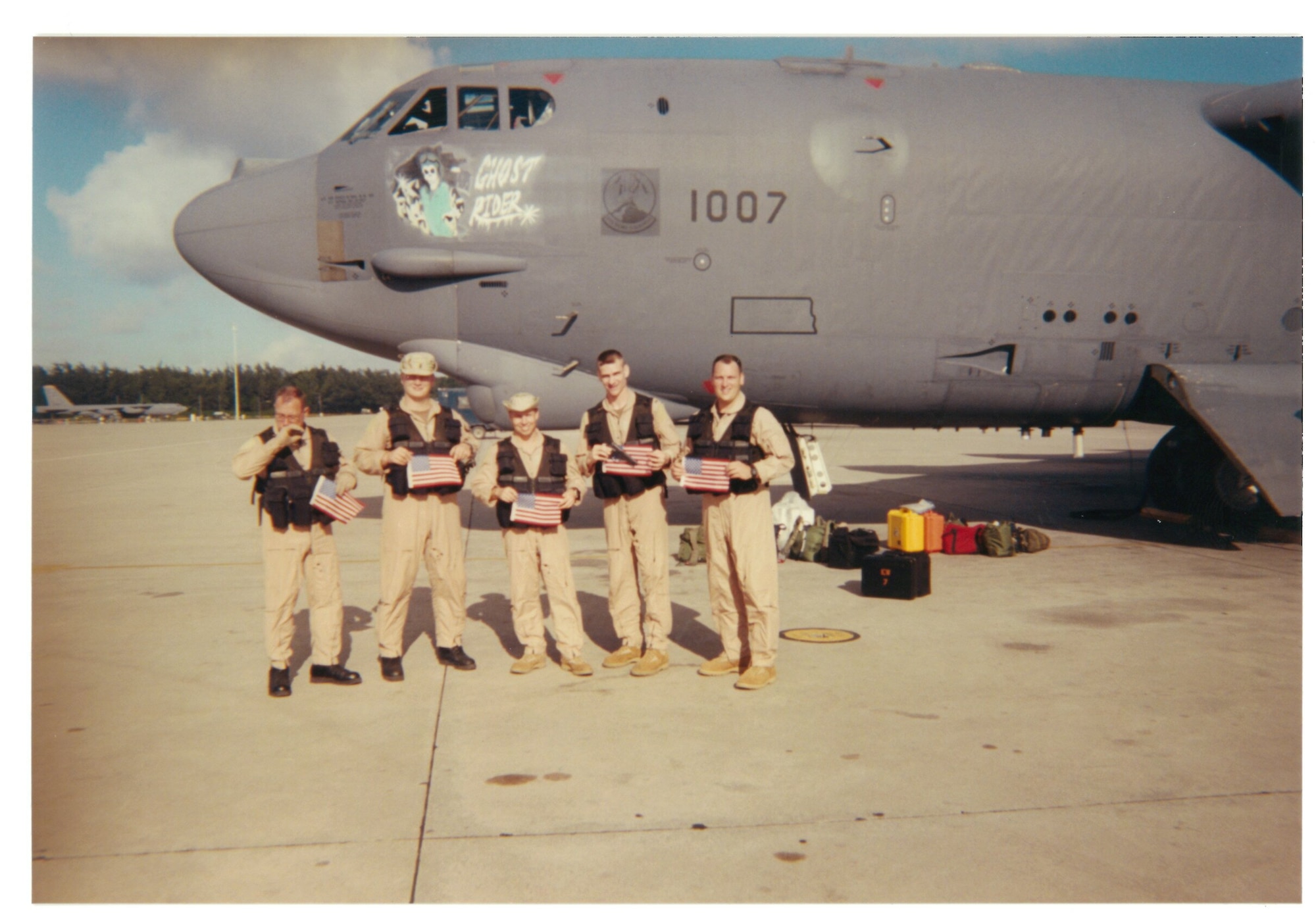 Capt. Doug Warnock (right) and other members of the 20th Expeditionary Bomb Squadron hold American flags in front of The B-52H Stratofortress 61-007, aka Ghost Rider, at Diego Garcia, July 2002. Warnock now serves as the 5th Bomb Wing operations group commander. (Courtesy Photo)