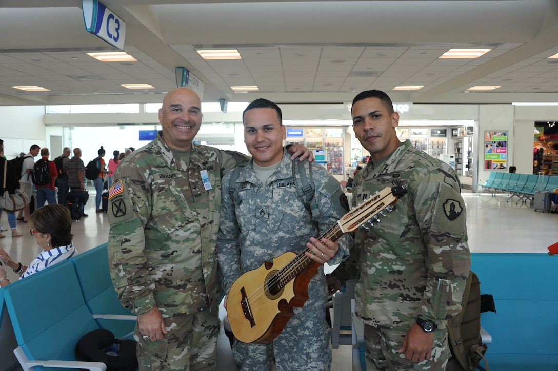 Building unit morale is a task that Staff Sgt. Nathanael Rivera (middle) brings upon himself. During previous deployments he was known for boosting morale by playing his guitar. “I enjoy playing the guitar for myself, to learn, and for the Soldiers to relieve stress,” said Rivera. “This time I brought a different instrument to make it more interesting and less mundane for the Soldiers.” Along with his Army issued equipment Rivera will travel with his cuatro guitar, which is the national instrument of Puerto Rico, on September 28 at Luis Muñoz Marin Airport in San Juan, Puerto Rico.