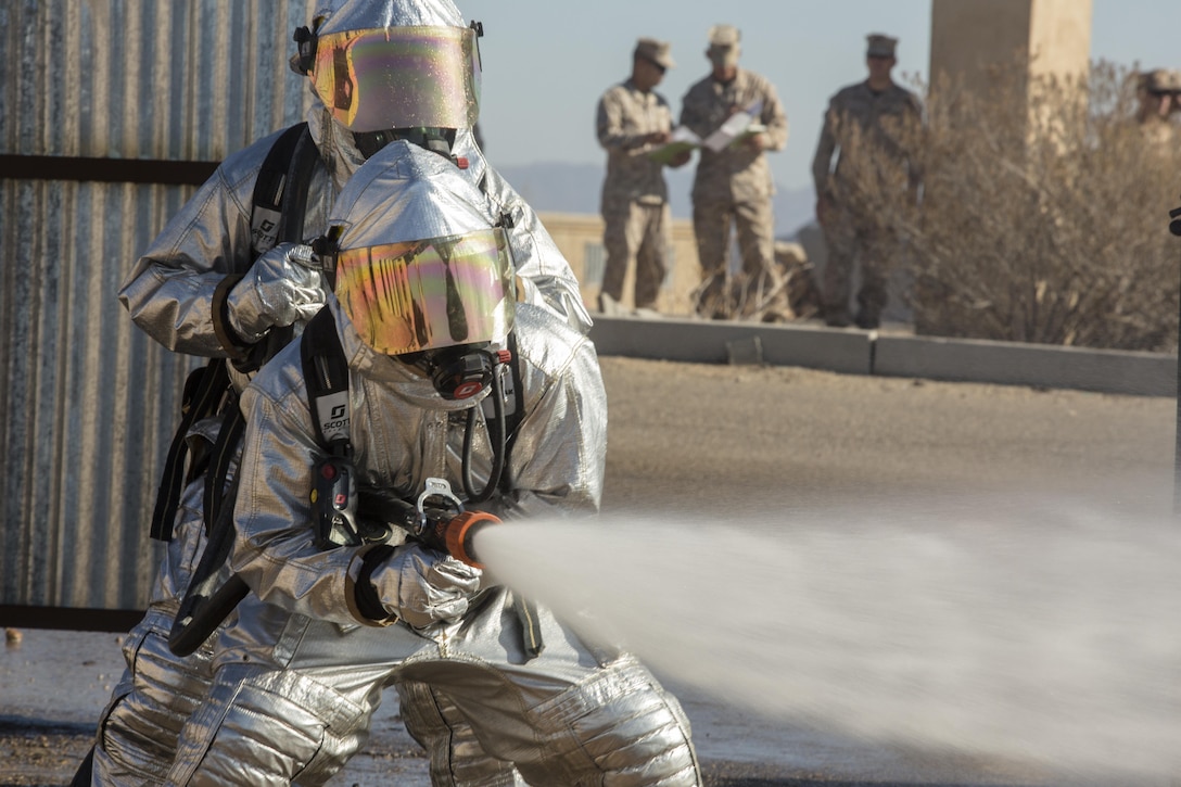 U.S. Marine Corps Cpl. Thomas Ream, left, and Sgt. Adrian Rosas, aircraft rescue and fire fighter specialists with Marine Wing Support Squadron 372, douse a downed aircraft during an aircraft salvage practical application exercise in support of Weapons and Tactics Instructor Course (WTI) 1-17 at Yuma Proving Ground, Ariz., Sept. 28, 2016. This exercise was part of WTI 1-17, a seven week training event, hosted by Marine Aviation Weapons and Tactics Squadron One (MAWTS-1) cadre, which emphasizes operational integration of the six functions of Marine Corps aviation in support of a Marine Air Ground Task Force. MAWTS-1 provides standardized advanced tactical training and certification of unit instructor qualifications to support Marine Aviation Training and Readiness and assists in developing and employing aviation weapons and tactics. (U.S. Marine Corps photo by Lance Cpl. Danny Gonzalez 1st MARDIV COMCAM)