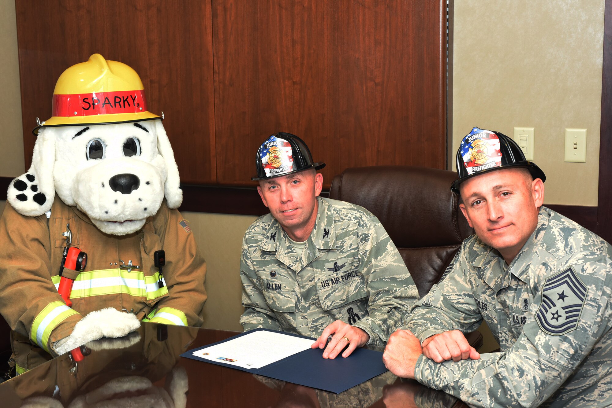 Col. Ronald Allen, 341st Missile Wing commander, center; Chief Master Sgt. Thomas Stiles, 341st Missile Wing command chief; and Sparky the Firedog officially recognize Fire Prevention Week as Oct. 9-15 at Malmstrom Air Force Base, Mont., with a signing of a proclamation Sept. 28, 2016.  (U.S. Air Force photo/Jason Heavner)