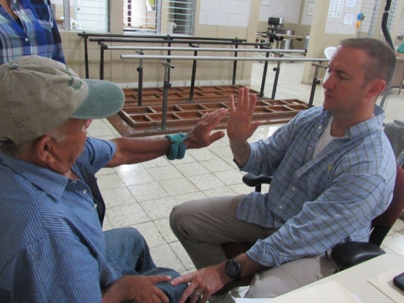 U.S. Army Maj. Jonathan Reagan, Joint Task Force Bravo Medical Element physical therapist, evaluates a Honduran stroke victim during a weekly visit to Centro de Rehabilitación Integral de Comayagua, August 3, 2016, where he treats Honduran patients and provides follow-up care for their rehabilitation process. These weekly missions are coordinated by the Ministry of Health of Comayagua and MEDEL missions and allow Reagan to provide the local community with musculoskeletal evaluations and interventions. (U.S. Army photo by 1st Lt Jenniffer Rodriguez)