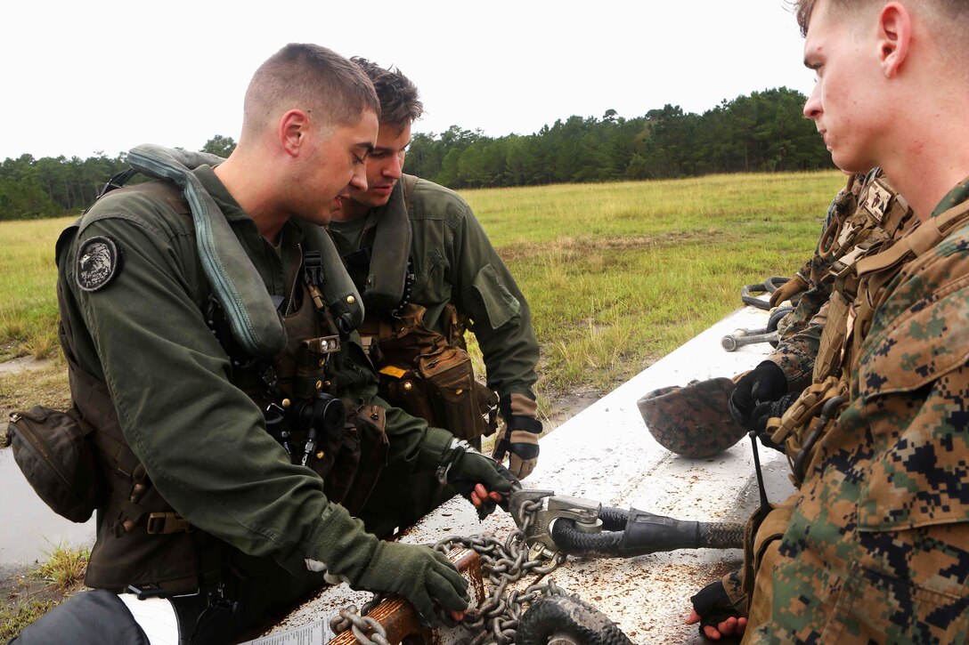 Marines inspect load hooks before participating in helicopter hoist training at Condor landing zone at Camp Lejeune, N.C., Sept. 20, 2016. The Marines are assigned to Marine Heavy Helicopter Squadron 464, Marine Aircraft Group 29, 2nd Marine Aircraft Wing, and Combat Logistics Battalion 26, Headquarters Regiment, 2nd Marine Logistics Group. Marine Corps photo by Lance Cpl. Jack A. E. Rigsby