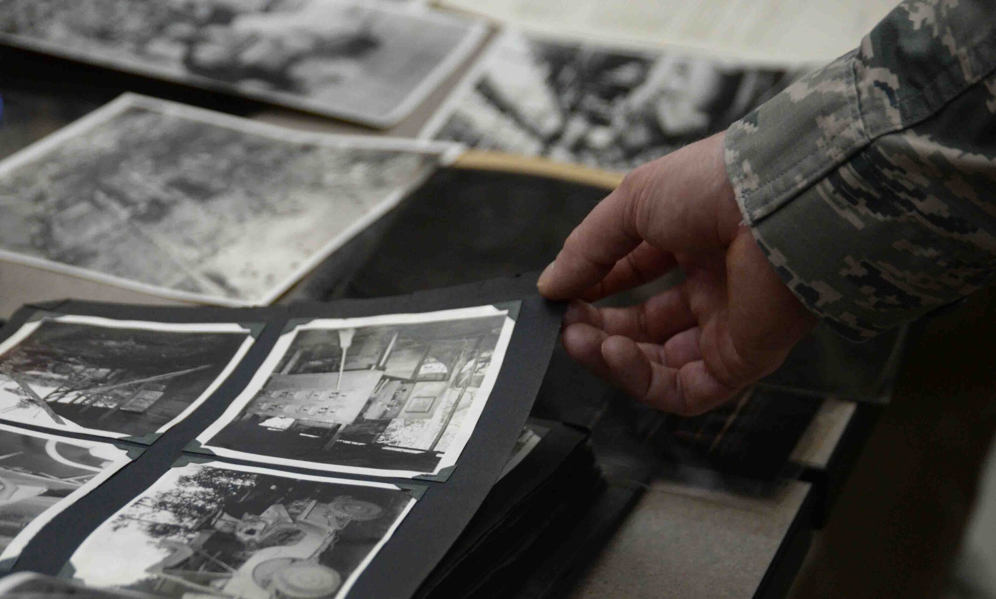 An Airman assigned to the National Air and Space Intelligence Center looks at photos taken by John “Jerry” Johnson, a member of the U.S. Army Air Corps 9th Photographic Technical Squadron during World War II, during a meet and greet session with National Air and Space Intelligence Center and 14th Intelligence Squadron Airmen on Wright-Patterson Air Force Base, Ohio, Sept. 23, 2016. The 14th Intelligence Squadron, is an Air Force Reserve Command unit assigned to the Air Force Life Cycle Management Center. The unit works in collaboration with NASIC and traces its lineage to the 9th PTS. (U.S. Air Force Photo/Master Sgt. Tammie Moore) 