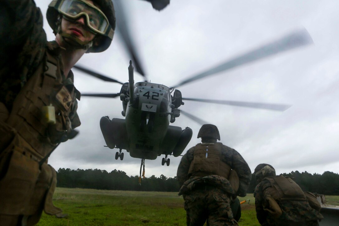 Marines prepare to hook a metal girder to a CH-53 Sea Stallion helicopter during hoist training at Condor landing zone at Camp Lejeune, N.C., Sept. 20, 2016. Marine Corps photo by Lance Cpl. Jack A. E. Rigsby