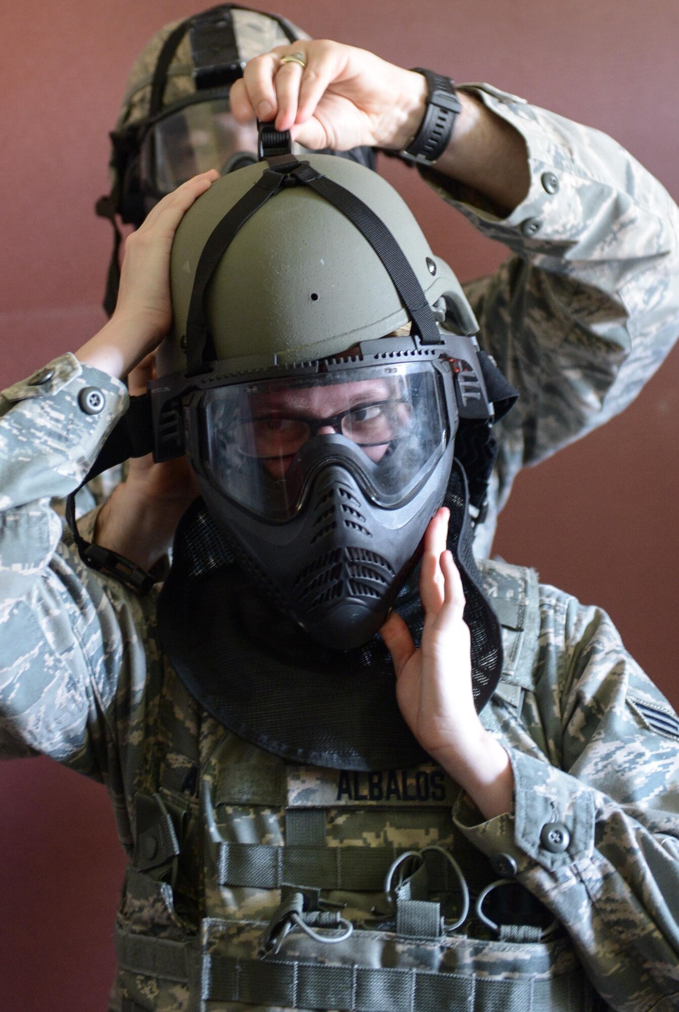 Master Sgt. Paul Stacey, 2nd Security Forces Squadron flight chief, helps Senior Airman Samantha Albalos, 2nd SFS entry controller, secure protective gear at Barksdale Air Force Base, La., July 18, 2016. The squadron conducted the training in teams of two, rather than their usual four-person teams, because a typical team responding to a real-world situation consists of two Airmen.  (U.S. Air Force photo/Senior Airman Curt Beach)