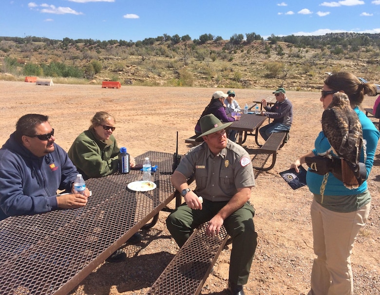 ABIQUIU LAKE, N.M., -- A representative from The Wildlife Center shows park manager John Mueller (center) and other volunteers an interpretive red tailed hawk, Sept. 24, 2016.