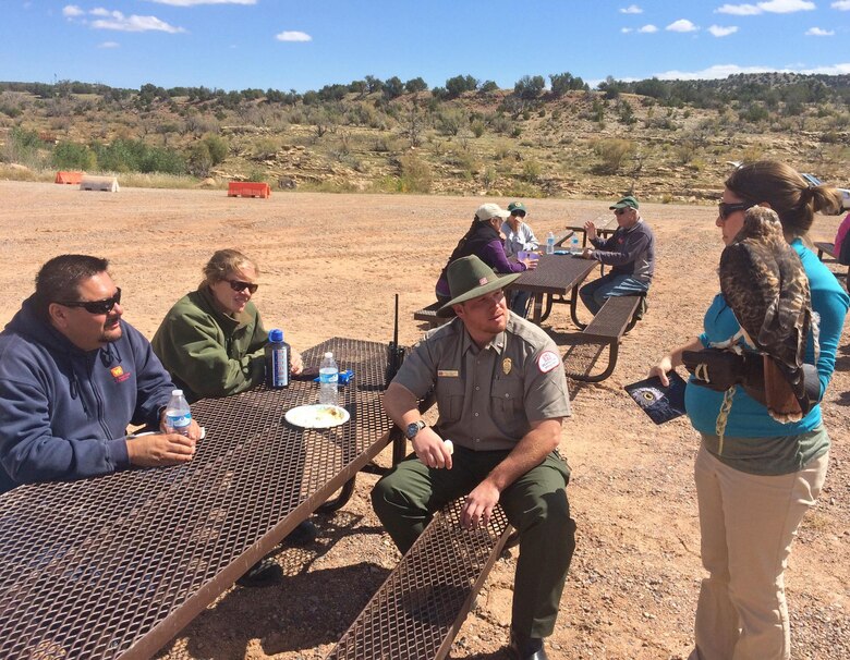 ABIQUIU LAKE, N.M., -- A representative from The Wildlife Center shows park manager John Mueller (center) and other volunteers an interpretive red tailed hawk, Sept. 24, 2016.