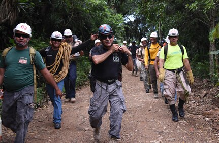 Herberth Gaekel (middle), 612th Air Base Squadron Fire Department liaison at Soto Cano Air Base, Honduras, and PUMCIR (Personal Utilizado en Misiones Contra Incendio y Rescate – Personnel Used in Fire and Rescue) founder and instructor, leads 13 Honduran and seven U.S. volunteers on the first leg of a six-mile round-trip hike into the mountains of Comayagua National Park near El Volcan, Honduras, Sept. 24, 2016, to conduct realistic search and rescue training. The all-volunteer group was comprised of Honduran Bomberos and a doctor from the surrounding region and seven U.S. Air Force Airmen assigned to Joint Task Force-Bravo that included firefighters and Personnel Recovery Coordination Cell members. (U.S. Air Force photo by Capt. David Liapis)