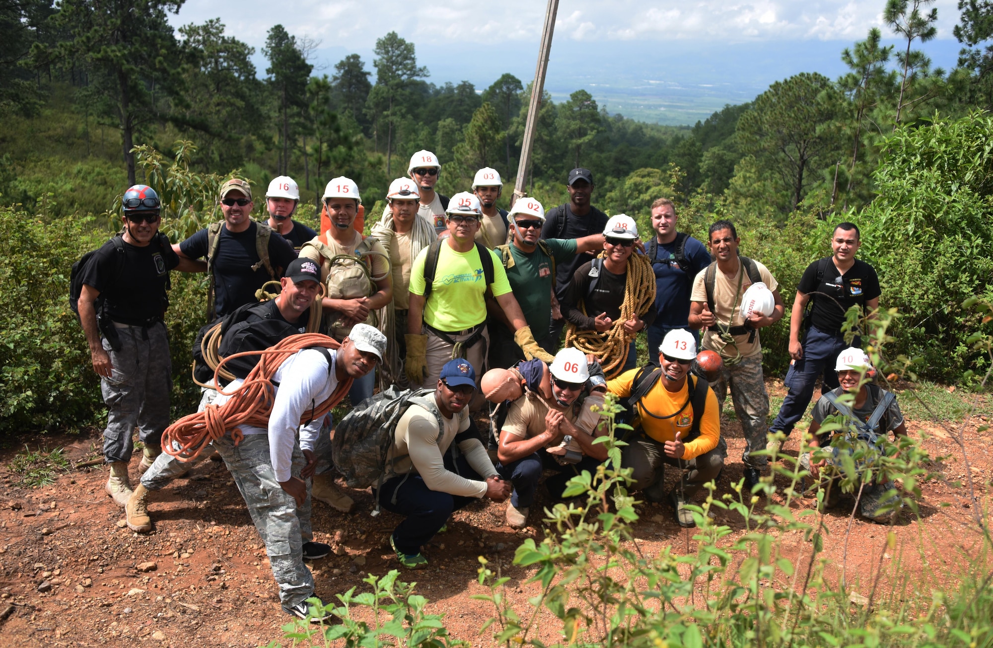 Thirteen Honduran PUMCIR (Personal Utilizado en Misiones Contra Incendio y Rescate – Personnel Used in Fire and Rescue) volunteers and six U.S. Air Force Airmen assigned to Joint Task Force-Bravo who included firefighters and Personnel Recovery Coordination Cell members, led by Herberth Gaekel (left), 612th Air Base Squadron Fire Department liaison at Soto Cano Air Base, Honduras, and PUMCIR founder and instructor, pose for a photo midway through a three-mile hike up to a cave located in Comayagua National Park near El Volcan, Honduras, Sept. 24, 2016, to conduct search and rescue training. Gaekel seeks to involve U.S. service members in order to provide them an opportunity to share with and learn from their Honduran counterparts as well as to encourage positive relationship building between the two nations. Gaekel said the training he provides significantly augments what training the volunteers, who are also often full or part-time Bomberos, already receive, and in many cases would not receive if not for his program. (U.S. Air Force photo by Capt. David Liapis) 