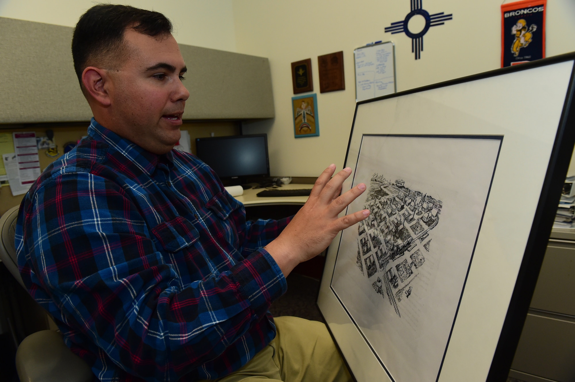 Christopher McCune, 460th Space Wing historian, explains a historical map Sept. 26, 2016, at the 460th Space Wing Headquarters building on Buckley AFB, Colo. As a historian, McCune must provide commanders with historical information to broaden their decision making ability that can affect today’s mission. (U.S. Air Force photo by Airman 1st Class Gabrielle Spradling/Released)