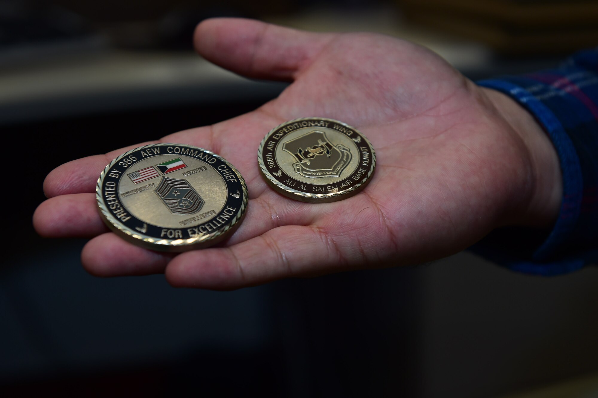 Christopher McCune, 460th Space Wing historian, displays two coins he received while on deployment Sept. 26, 2016, at the 460th Wing Headquarters building on Buckley Air Force Base, Colo. U.S Air Force historians serve as one of the few civilian positions within the federal government that receive deployment taskers. (U.S. Air Force photo by Airman 1st Class Gabrielle Spradling/Released)
