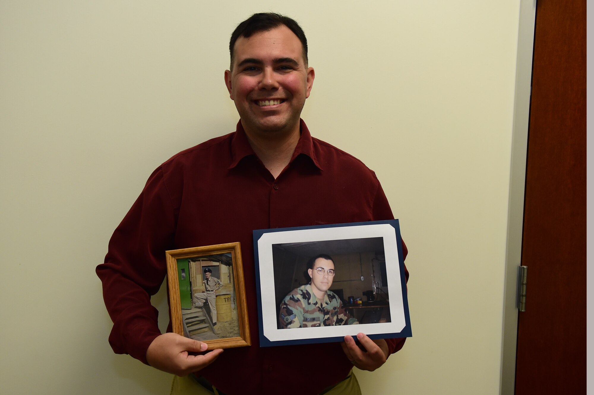 Christopher McCune, 460th Space Wing historian, displays photos of himself and his grandfather during their time in service Sept. 27, 2016, at the 460th Wing Headquarters building on Buckley Air Force Base, Colo. Most Air Force historians possess prior military experience, McCune included, which is helpful to obtaining a security clearance to perform their duties. (U.S. Air Force photo by Airman 1st Class Gabrielle Spradling/Released)