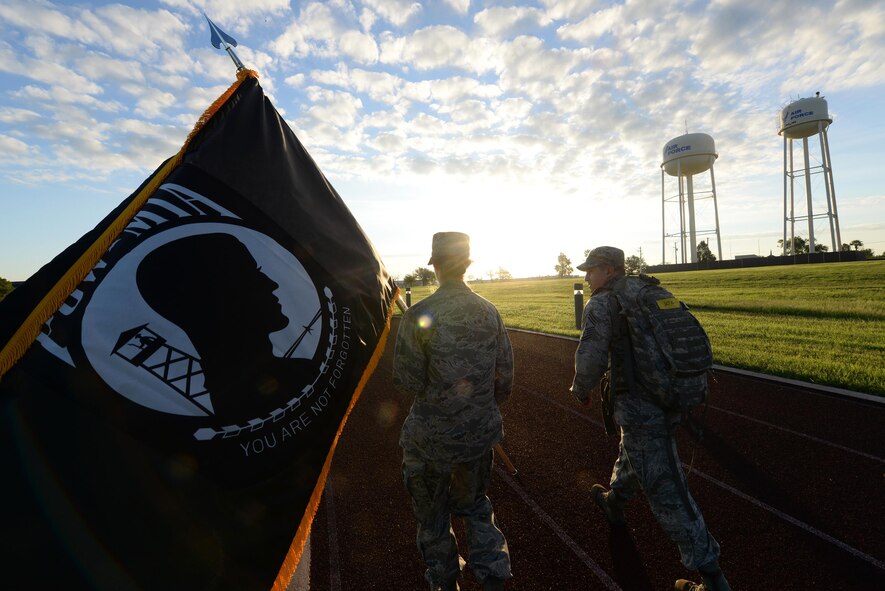 Colonel Michelle Pryor, 47th Flying Training Wing vice commander (left), and Chief Master Sgt. George Richey, 47th FTW command chief (right), take their turn carrying the POW/MIA flag during a memorial ruck march on Laughlin Air Force Base, Texas, Sept. 16, 2016. The ruck march lasted for 24 hours and was in memory of those missing or captured during battle. (U.S. Air Force photo/ Airman 1st Class Benjamin N. Valmoja)