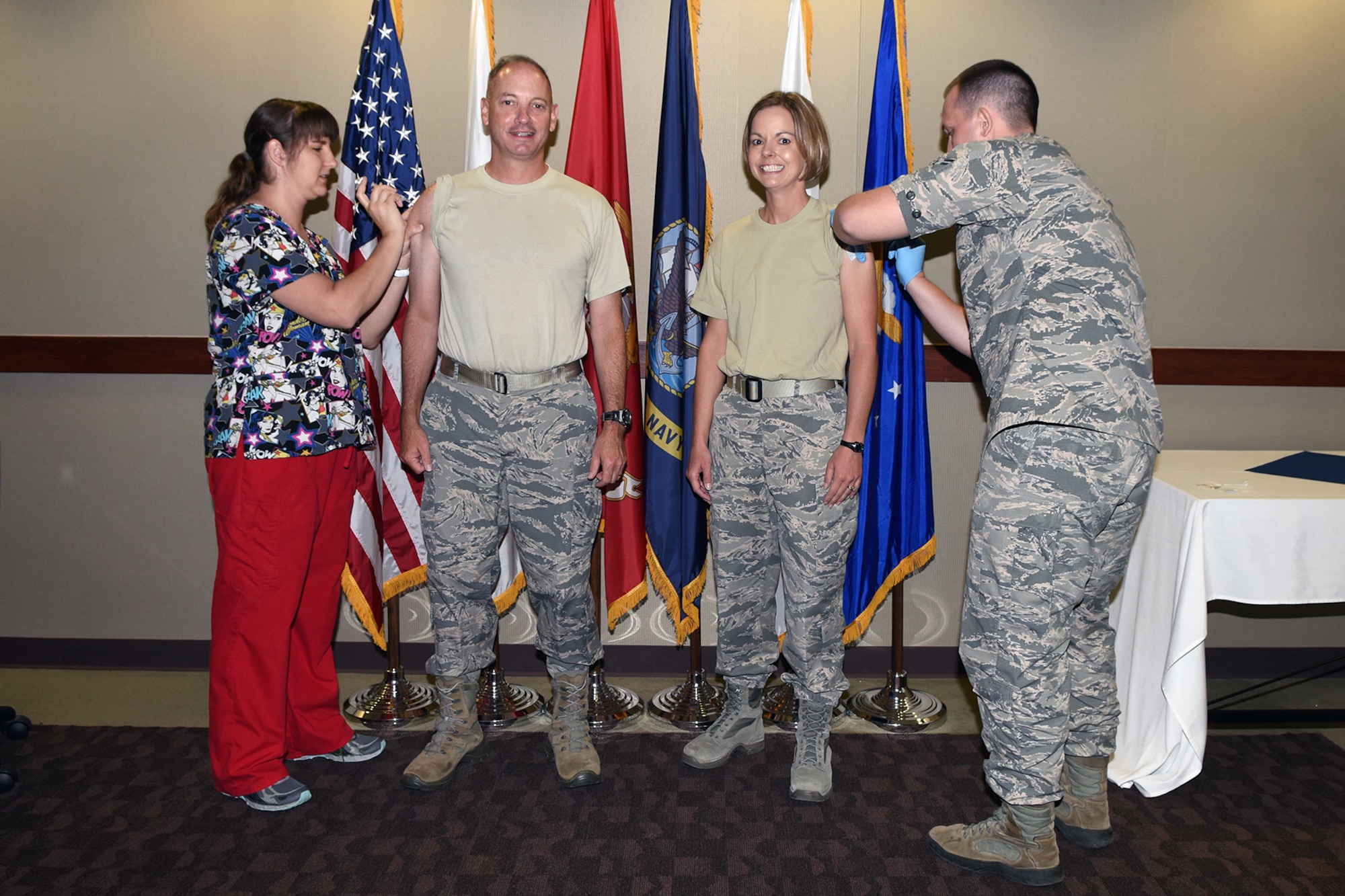 U.S. Air Force Col. Michael Downs, 17th Training Wing Commander, and Chief Master Sgt. Bobbie Reinsche, 17th TRW Command Chief, receive their flu shots from Tiffany Jones, 17th Medical Operations Squadron family practice registered nurse, and Airman 1st Class Danny Smith Jr., 17th MDOS aerospace medical technician, at the Norma Brown building on Goodfellow Air Force Base, Texas, Sept. 29, 2016. All active duty military members are required to receive the flu vaccination annually. (U.S. Air Force photo by Staff Sgt. Laura R. McFarlane/Released)