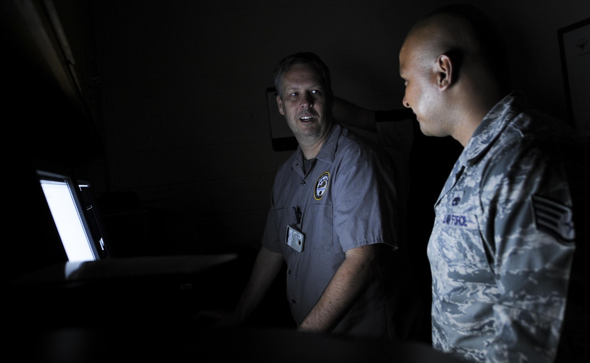 Charles Duke, M1 non-destructive inspection technician, and Staff Sgt. John Mantanona, 823rd Maintenance Squadron NDI craftsman, discuss an x-ray on the screen during training in the NDI Lab on Nellis Air Force Base, Nev., Sept. 28. The NDI Lab inspects aircraft structures and sub-assemblies for defects and foreign objects by performing oil analysis, fluorescent dye penetrant, fluorescent magnetic particle, ultrasonic, eddy current and radiographic inspections. (U.S. Air Force photo by Airman 1st Class Kevin Tanenbaum/Released)