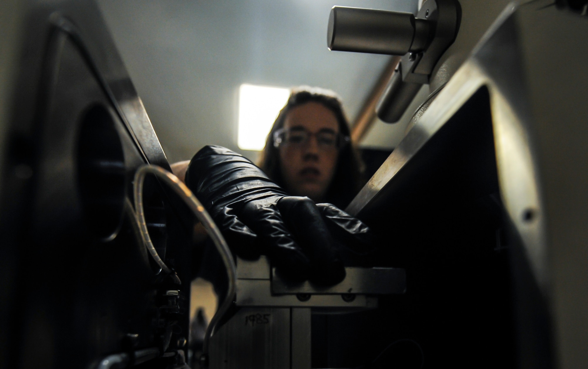 Stephanie Ramirez, M1 non-destructive inspection technician, places a sample tray into an electron microscope for testing in the NDI Lab on Nellis Air Force Base, Nev., Sept. 28. The NDI Lab provides support for approximately 120 permanently assigned aircraft and more than 500 visiting aircraft throughout the year. (U.S. Air Force photo by Airman 1st Class Kevin Tanenbaum/Released)