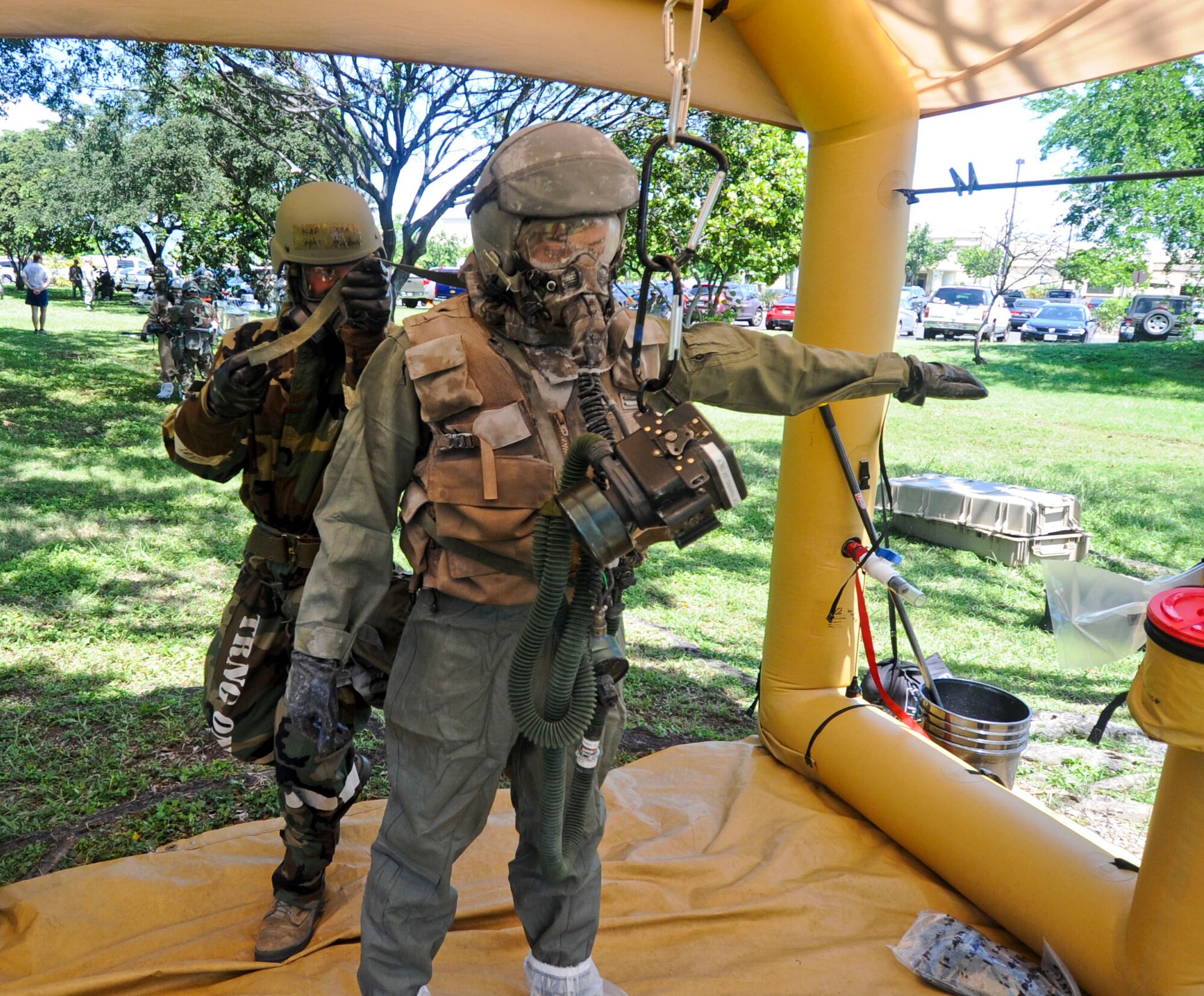 An aircrew flight equipment Airman removes external protective equipment from an aircrew member during the Aircrew Contamination Control Area (ACCA) process as part of Exercise Toxic Pineapple on Joint Base Pearl Harbor-Hickam, Hawaii, Sept. 16, 2016.  The exercise, which was hosted by the 15th Operations Support Squadron, saw 28 aircrew flight equipment Airmen from Pacific Air Forces, Air Combat Command, and the Air Force Reserve Command learn to set up and run an Aircrew Contamination Control Area in a simulated deployed environment. (U.S. Air Force photo by Tech. Sgt. Terri Paden/Released)