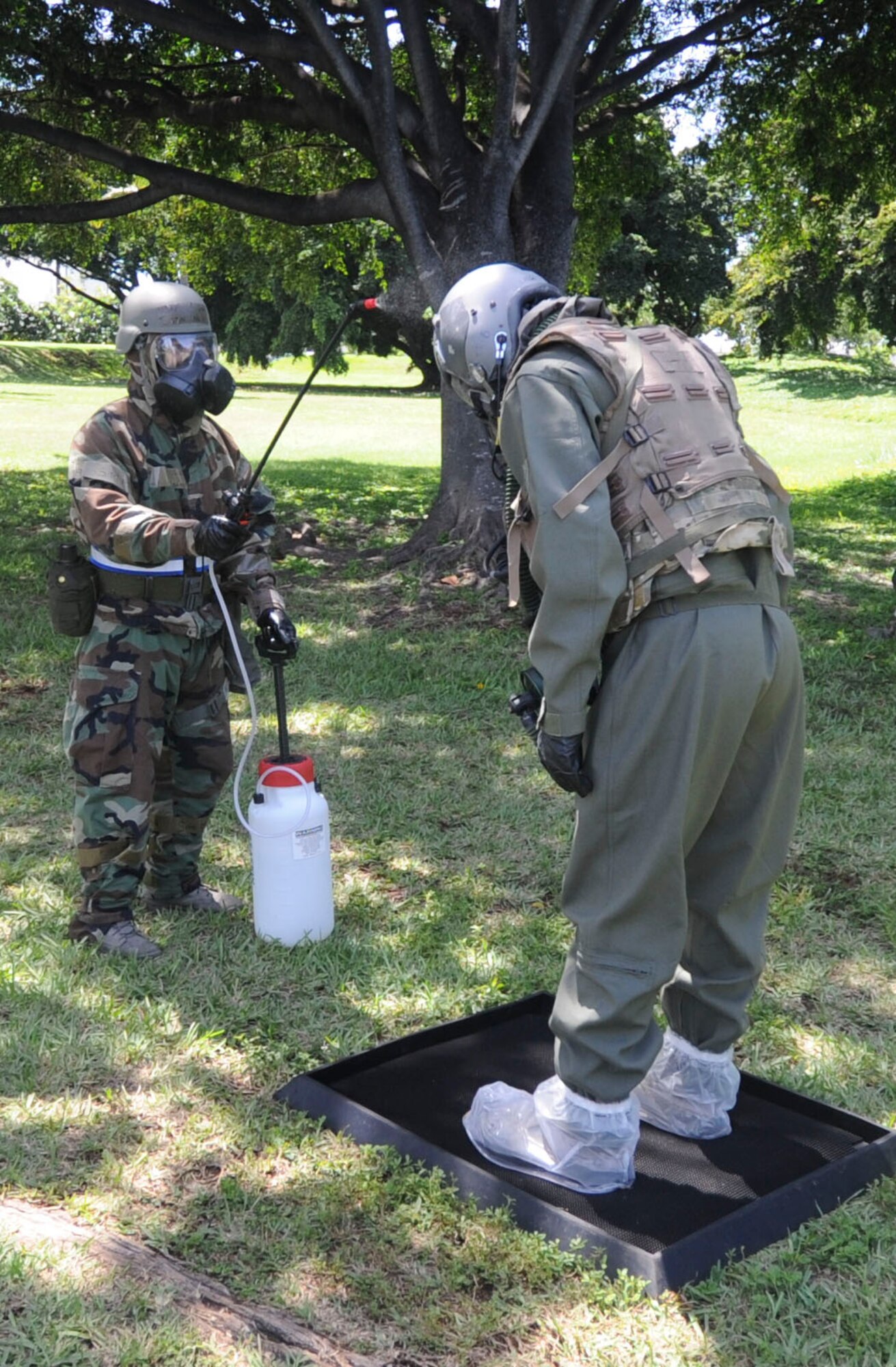 An aircrew flight equipment Airman sprays a 5% chlorine bleach solution to simulate removing contamination from an aircrew member during the Aircrew Contamination Control Area (ACCA) process as part of Exercise Toxic Pineapple on Joint Base Pearl Harbor-Hickam, Hawaii, Sept. 16, 2016.  The bleach solution is used to remove as much contamination from the aircrew member and equipment as possible before proceeding with the process. The exercise, which was hosted by the 15th Operations Support Squadron, saw 28 aircrew flight equipment Airmen from Pacific Air Forces, Air Combat Command, and the Air Force Reserve Command learn to set up and run an Aircrew Contamination Control Area in a simulated deployed environment. (U.S. Air Force photo by Tech. Sgt. Terri Paden/Released)