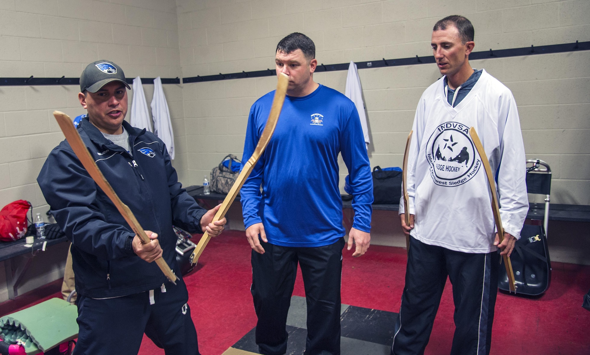 Master Sgt. Richard Ortega, Fairchild Falcons varsity hockey team president, shows off the sticks used in sled hockey to his teammates before the before an exhibition match at the Frontier Ice Arena here in Coeur d’Alene, Idaho, Sept. 23, 2016. Sled hockey is a sport designed for athletes with physical disabilities. Specialized gear allows them to play the game of ice hockey with some slight modifications; it is one of the most popular sports in the Winter Paralympic Games. (U.S. Air Force photo/Tech. Sgt. Travis Edwards)