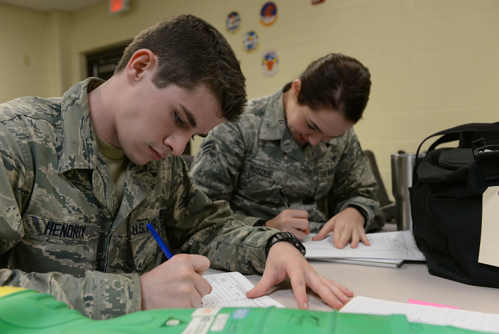Airman 1st Class Jesse Hendrix (left), 47th Medical Operations Squadron aerospace and operational physiology technician, and Senior Airman Juliana Busque (right), 47th Medical Support Squadron command support staff technician, take notes during a decontamination training course on Laughlin Air Force Base, Texas, Sept. 22, 2016. The two took part in a two-day training exercise that highlighted down-range decontamination procedures. (U.S. Air Force photo/Airman 1st Class Benjamin N. Valmoja)