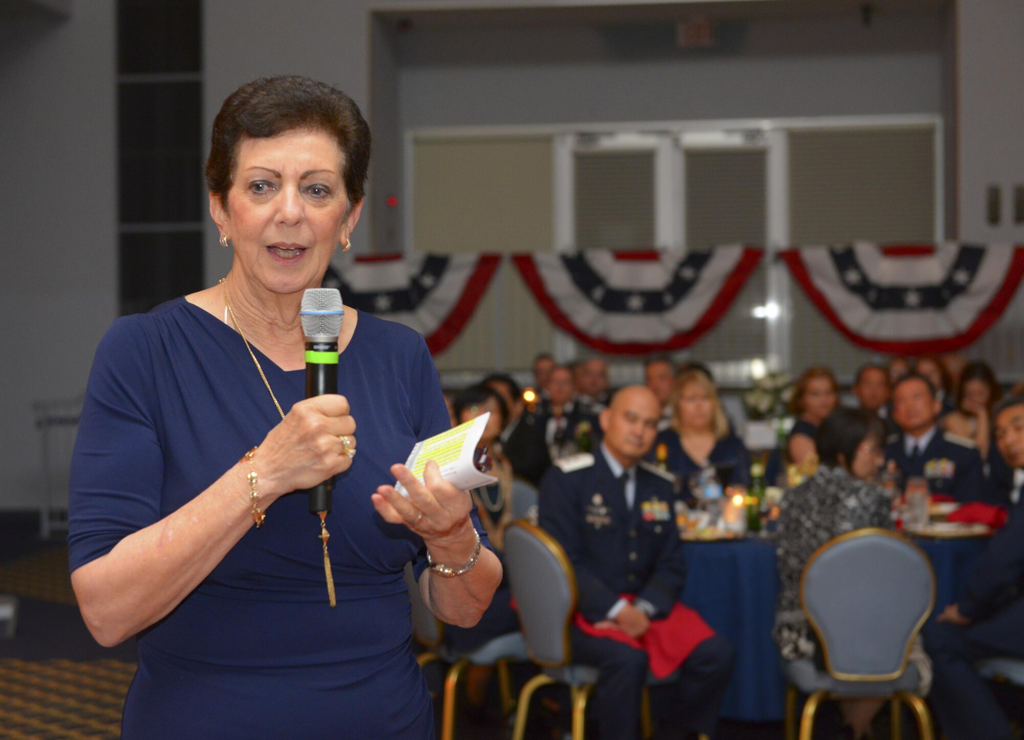 Retired Air Force Col. Regina Aune addresses the crowd during the 69th Annual Air Force Ball at Yokota Air Base, Japan, Sep. 23, 2016. In 1974, Aune helped save orphans from a downed aircraft during Operation Baby Lift. Aune spoke about how to be a hero in the everyday routine of life. (U.S. Air Force photo by Airman 1st Class Elizabeth Baker/Released)