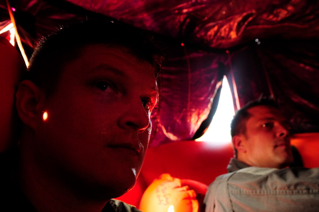 U.S. Air Force Capt. Ash Smith, 156th Airlift Squadron (left), listens to instruction on energy and resource conservation under a canopy in a 20-man lift raft during a water survival refresher course held at Camp John J. Barnhardt, New London, N.C., Sept. 10, 2016. In a water emergency aircrew members must prepare to be stranded for an unknown amount of time. The course is an annual requirement which covers water survival equipment and procedures to prepare aircrew members for parachuting into water or an aircraft incident over water. (U.S. Air National Guard photo by Staff Sgt. Julianne M. Showalter)