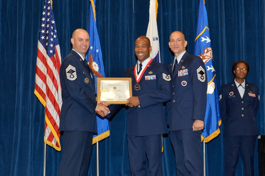 Tech. Sgt. John Lewis, right, receives the Distinguished Graduate Award for NCO academy class 16-6 from Chief Master Sgt. Paul Rayman, Chief Master Sgt. of Reserve Forces for Headquarters Air Force Space Command, and Chief Master Sgt. Edward Walden, Sr., Commandant of the Paul H. Lankford Enlisted PME Center, here, Sep. 29, 2016, at the I.G. Brown Training and Education Center in Louisville, Tenn. The distinguished graduate award is presented to the top 10 percent of the class.   (U.S. Air National Guard photo by Master Sgt. Jerry D. Harlan/Released)