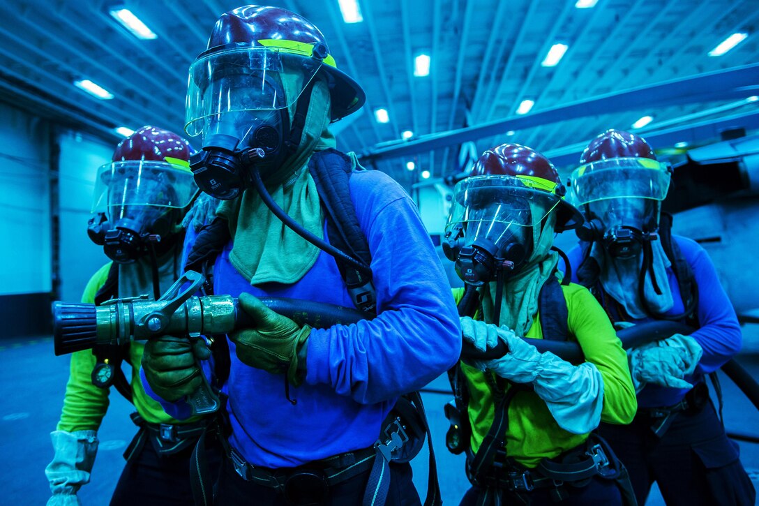 Sailors aboard the USS Bonhomme Richard fight a simulated fire during a training scenario in the South China Sea, Sept. 28, 2016. The amphibious assault ship is supporting security and stability in the Indo-Asia Pacific region. Navy photo by Petty Officer 1st Class David Holmes