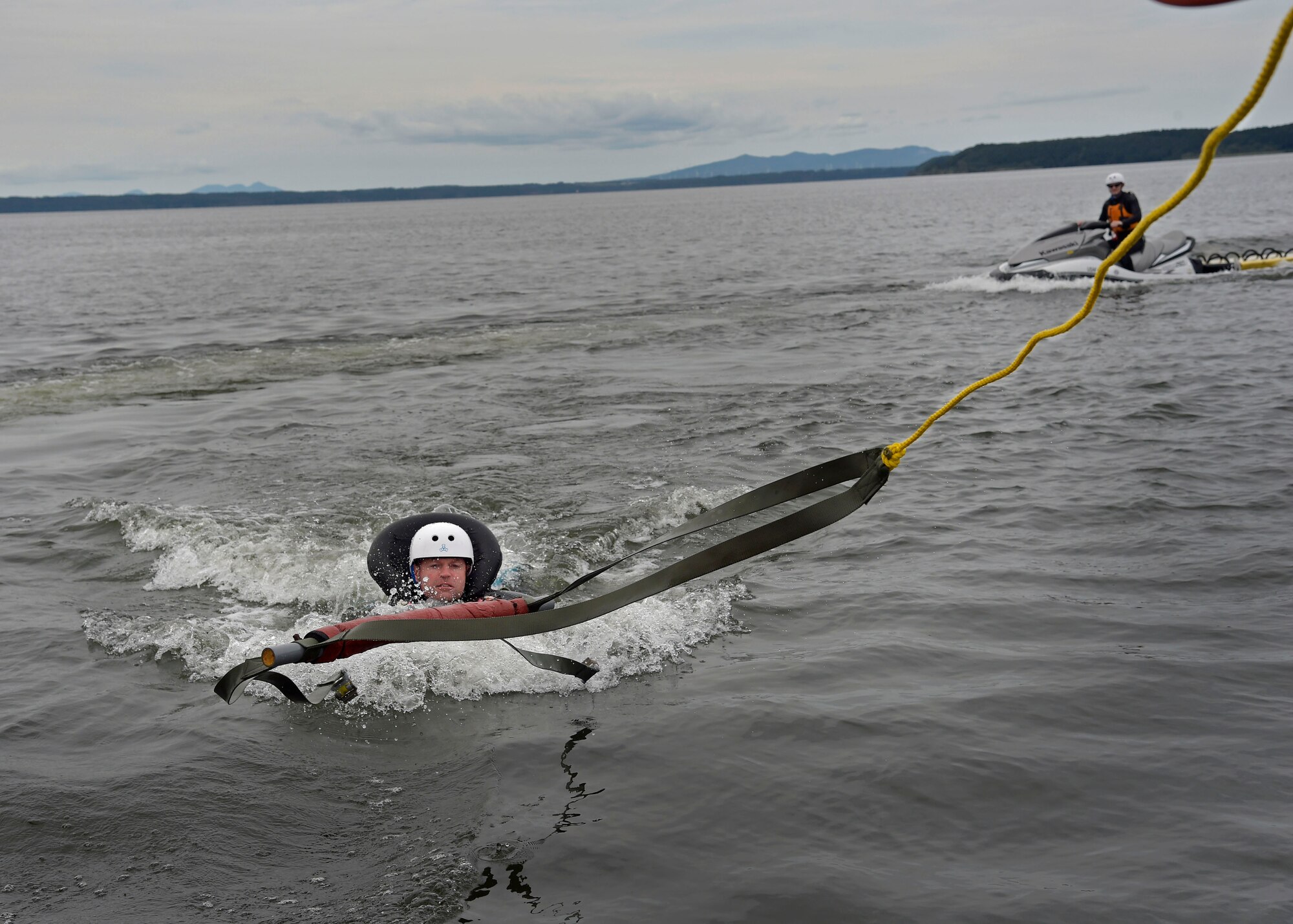 U.S. Air Force Lt. Col. Westly Hales, incoming 35th Fighter Wing chief of advanced programs, demonstrates a parachute drag across Lake Ogawara at Misawa Air Base, Japan, Sept. 20, 2016. Survival, Evasion, Resistance, and Escape specialists teach pilots how to properly and safely release themselves from a parachute being drug by the wind. Undergoing this training every three years is critical to the pilots because it may be the only time they are able to demonstrate these techniques before an emergency situation. (U.S. Air Force photo by Senior Airman Deana Heitzman)