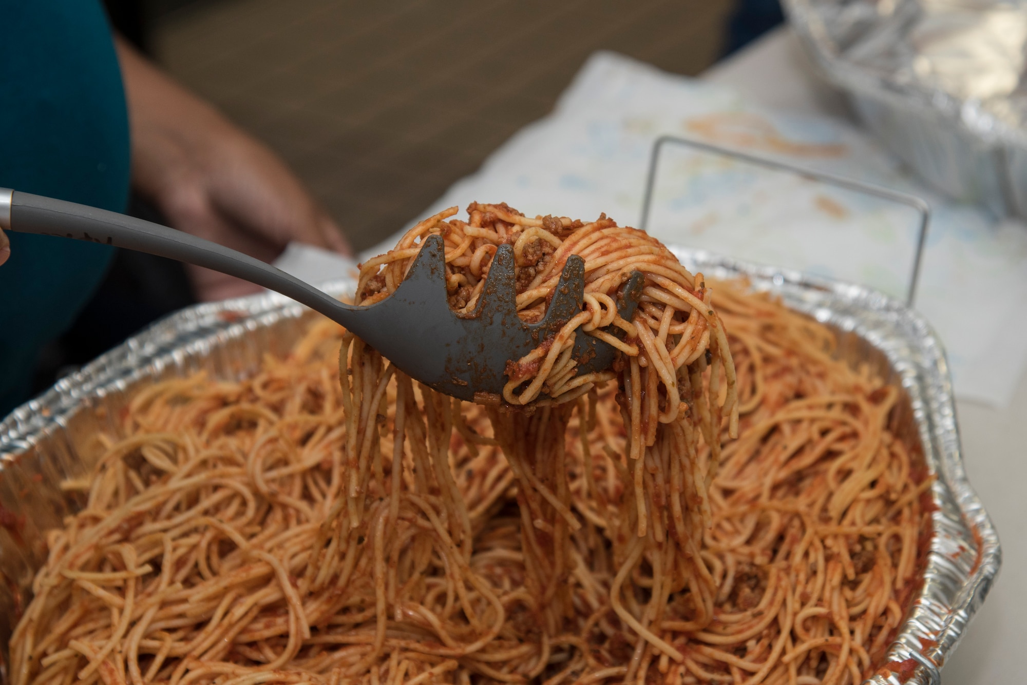 Nicole Davenport, spouse of U.S. Air Force Staff Sgt. Roddrick Davenport, a 35th Maintenance Squadron avionics specialist, serves spaghetti during a "Hearts on the Flight Line" event at Misawa Air Base, Japan, Sept. 28, 2016. The Chaplain Corps funded the event that brough Airmen home-cooked food in order to look after the Airmen's well-being. (U.S. Air Force photo by Airman 1st Class Sadie Colbert)