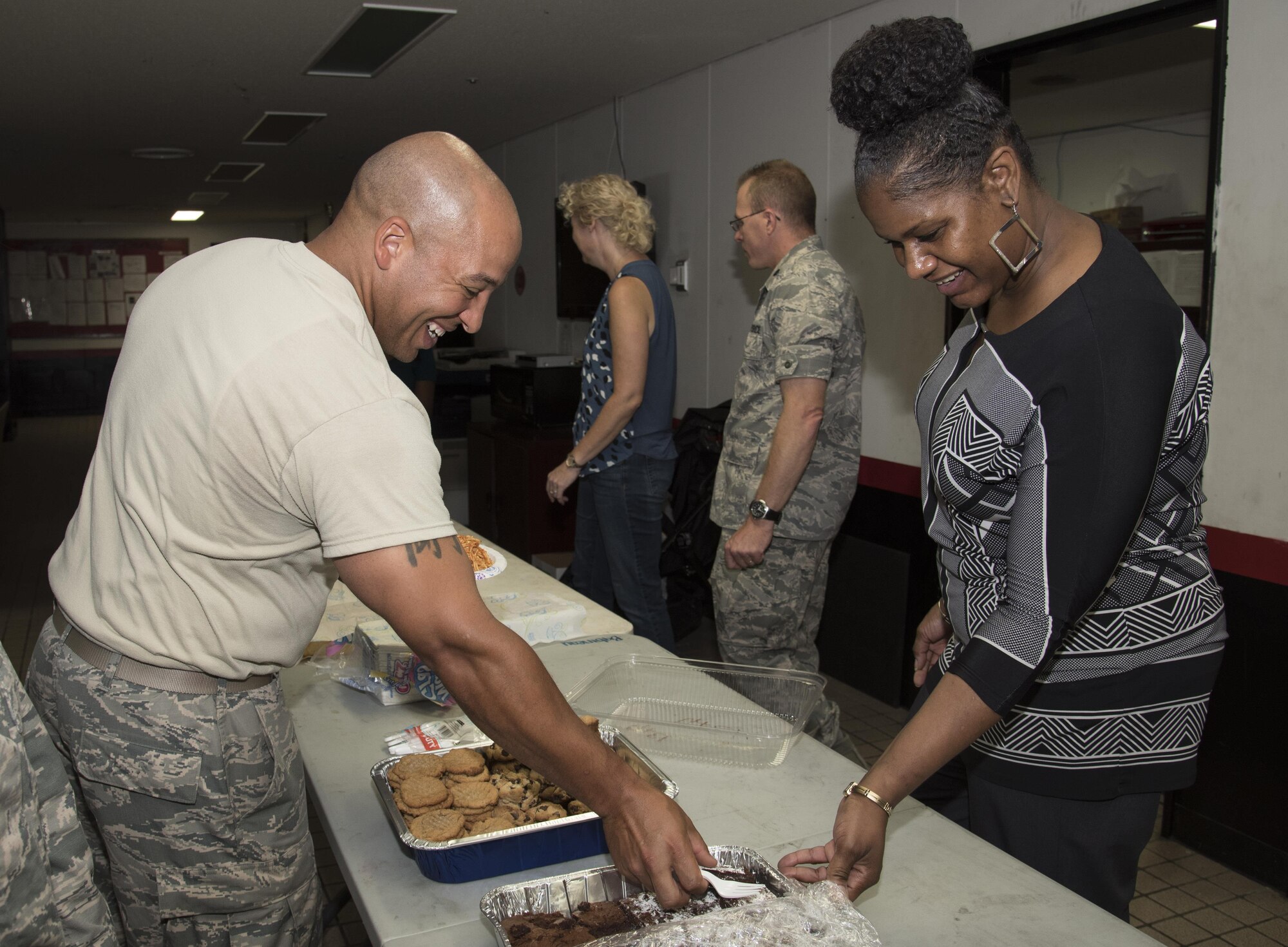 U.S. Air Force Tech. Sgt. Erik Bush, left, a 13th Aircraft Maintenance Unit equipment technician, receives a brownie from Natasha Fiers, right, the 35th Aircraft Maintenance Squadron commander's secretary, during a "Hearts on the Flight Line" event at Misawa Air Base, Japan, Sept. 28, 2016. Flightline personnel received spaghetti, rolls and various sweets during the event. Hearts on the Flight Line is coordinated by the Chaplain Corps and squadron leaders to provide home-cooked meals to Airmen. (U.S. Air Force photo by Airman 1st Class Sadie Colbert)