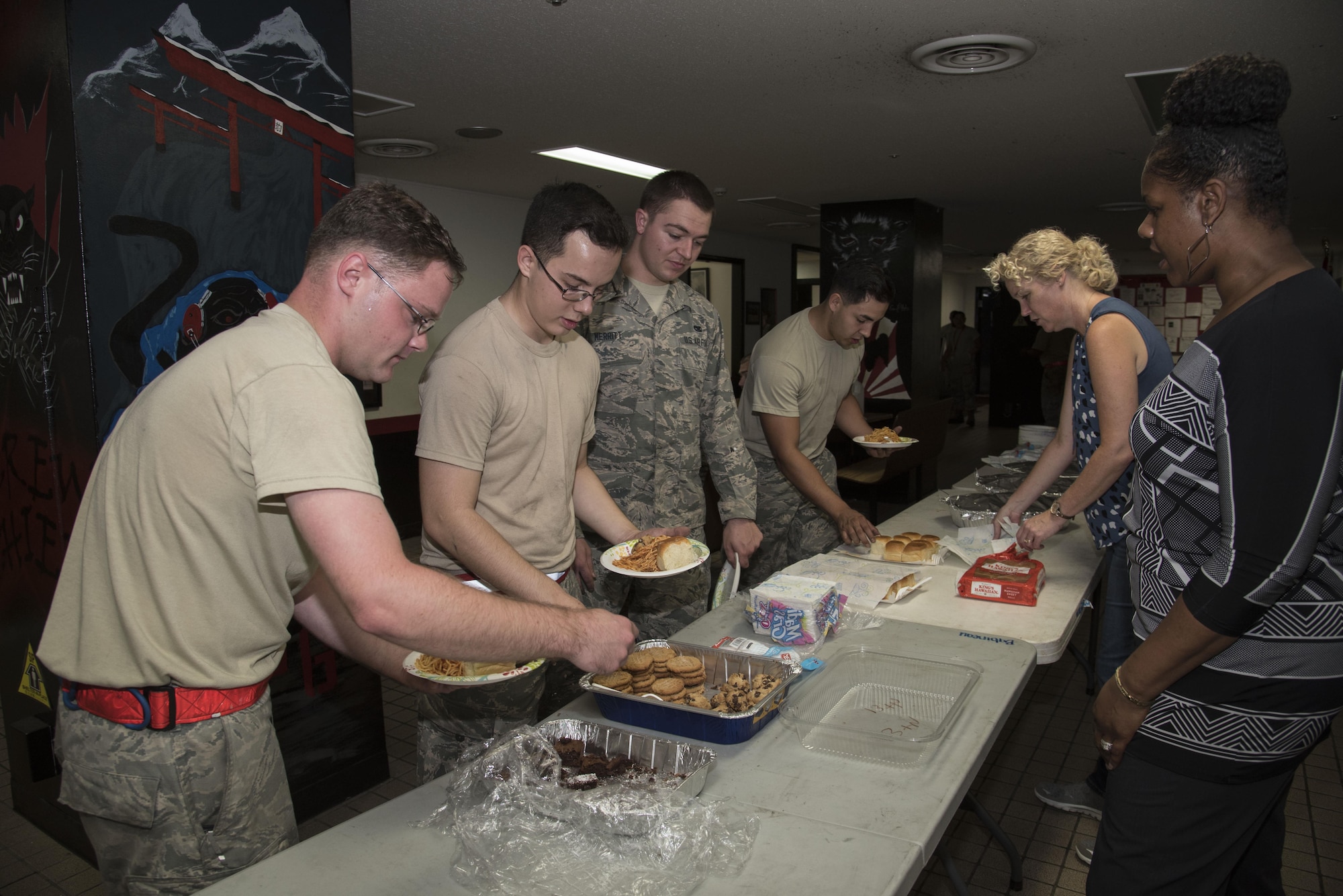 Airmen with the 13th Aircraft Maintenance Unit line up to receive food during a "Hearts on the Flight Line" event at Misawa Air Base, Japan, Sept. 28, 2016. Members of the Chaplan Corps held the event to show Airmen they are notied and can come to the chaplains and their assistants if there is anything they are struggling with. Hearts on the Flight Line is a program coordinated by the Chaplain Corps and squadron leadership enabling Airmen to relax from work stress by enjoying a home-cooked meal. (U.S. Air Force photo by Airman 1st Class Sadie Colbert)